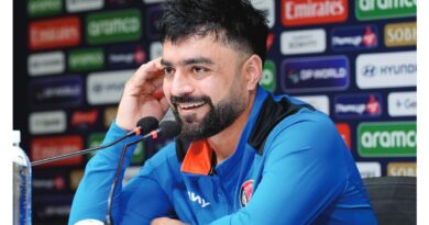 افغان کرکٹر راشد خان افغانستان کی جرسی میں ایک میچ کے دوران خوشی کا اظہار کرتے ہوئے، پس منظر میں کرکٹ گراؤنڈ واضح ہے۔