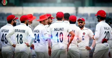 Afghanistan national cricket team players in white test uniform discussing on field during a match.