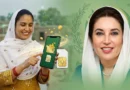 A professional news thumbnail for BISP showing a smiling Pakistani beneficiary woman holding a smartphone with a digital wallet app and a SIM card, alongside an official portrait of Benazir Bhutto on a green background.