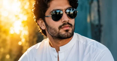 ایک باوقار پاکستانی مرد سفید شلوار قمیض اور کالے رنگ کا سن گلاسز (دھوپ کا چشمہ) پہنے ہوئے، جو گرمیوں میں آنکھوں کی حفاظت اور فیشن کو ظاہر کرتا ہے۔