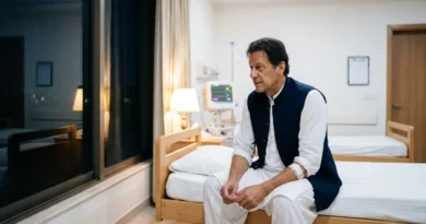 Imran Khan sitting thoughtfully in a hospital room in white clothing and a navy vest