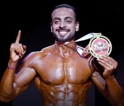 Pakistani Wapda athlete Hamza Raja holding the IFBB Mr Universe 2026 Overall Title and Pro Card in Switzerland.